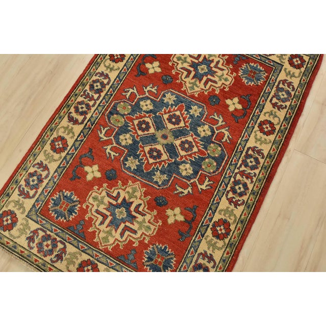 A tribal Caucasian Kazak rug hand-knotted with fine wool on a cotton foundation. This rug features a central medallion...