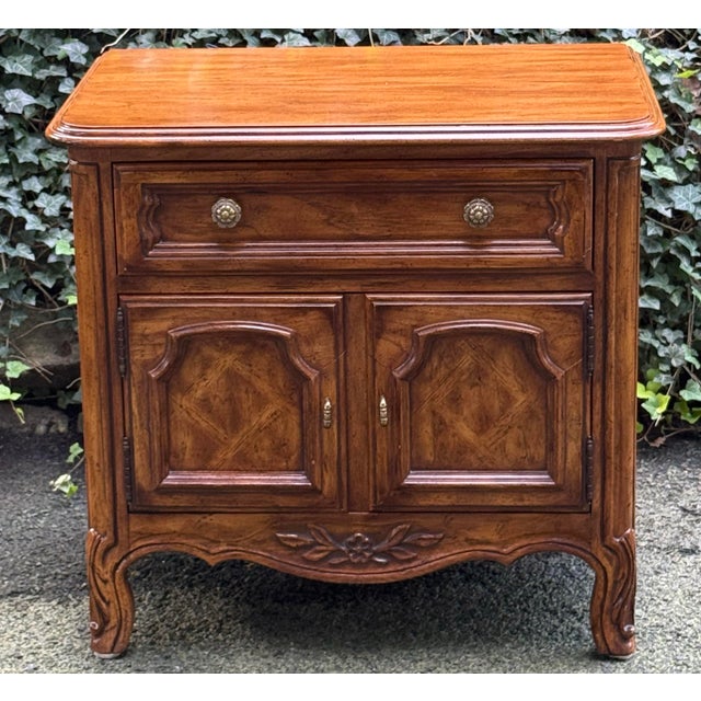 Beautiful French Provincial-style walnut nightstand or side cabinet featuring a warm, richly figured wood finish and...