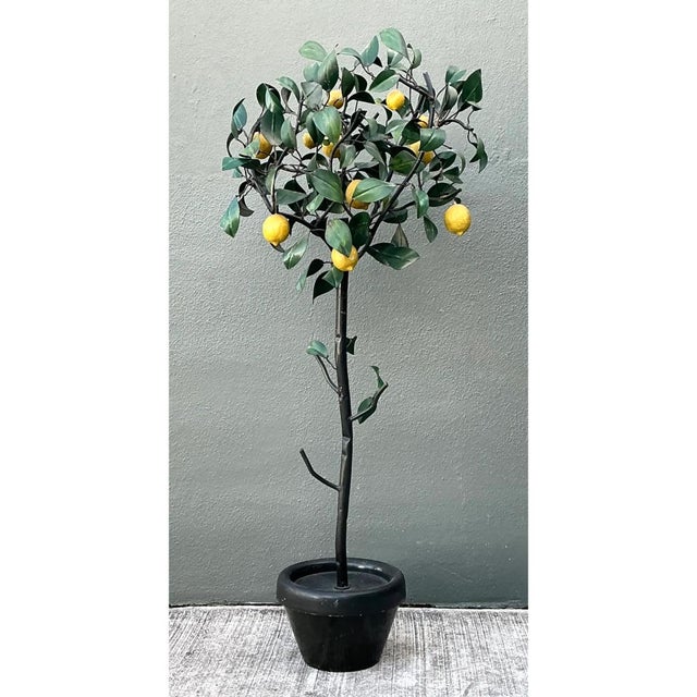 This vintage Italian painted metal lemon tree captures the sun-drenched whimsy of a Mediterranean courtyard in a...
