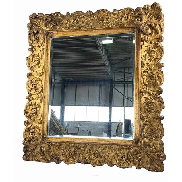 An impressive carved gilt wood mirror of large proportions. Probably italian late 19th century. Of rectangular form...