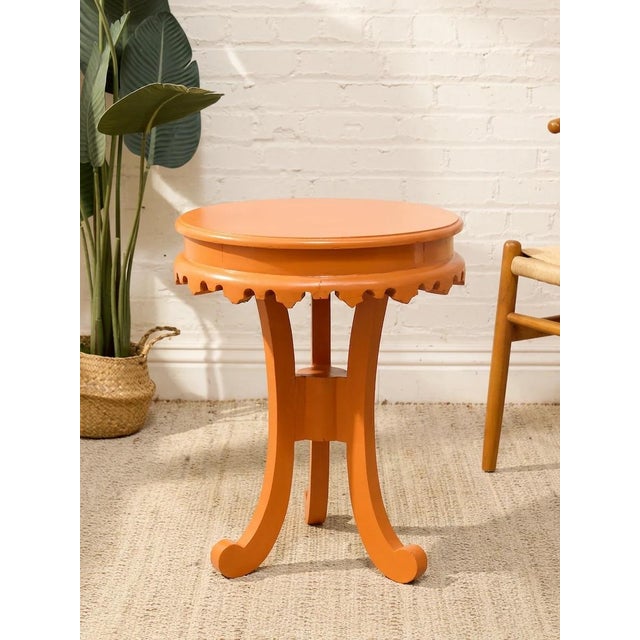 A playful vintage 1970s side table with a round top, decorative scalloped apron, and curving legs, finished in a soft...