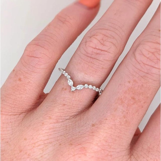 A graceful curved chevron band crafted in solid 14K gold, featuring a sparkling arrangement of marquise and round diamonds...