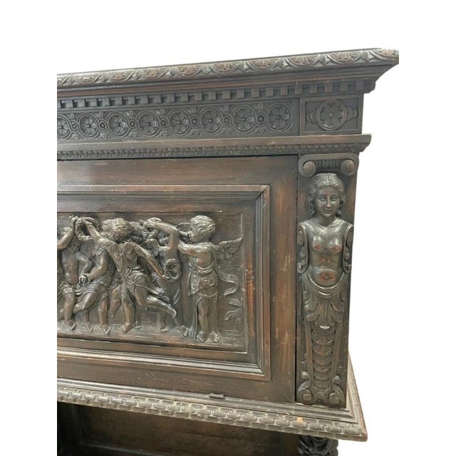 An exceptional antique Renaissance Revival carved wood cabinet featuring elaborate architectural carving and dramatic...