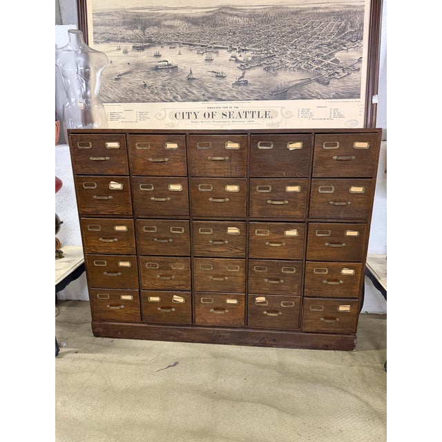 Large antique oak card catalog cabinet featuring 25 drawers with original brass label holders and pulls. Beautiful aged...