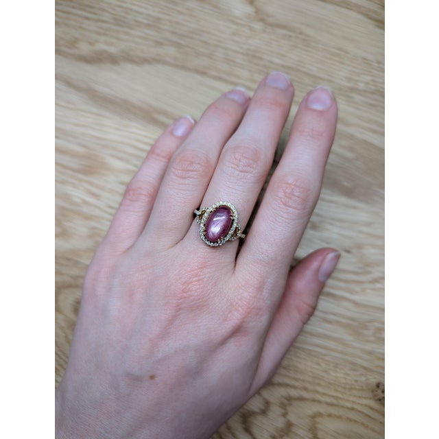 A star ruby glows in a deep red lit by a silver star at the centre of this solid 14K yellow gold ring, encircled by fifty-...