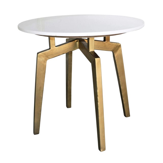 Round white marble top side table with four brass finish iron legs. Each may vary in natural marble differences.