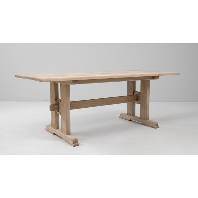 This 20th-century French oak trestle dining table exemplifies timeless craftsmanship and rustic refinement. Constructed...