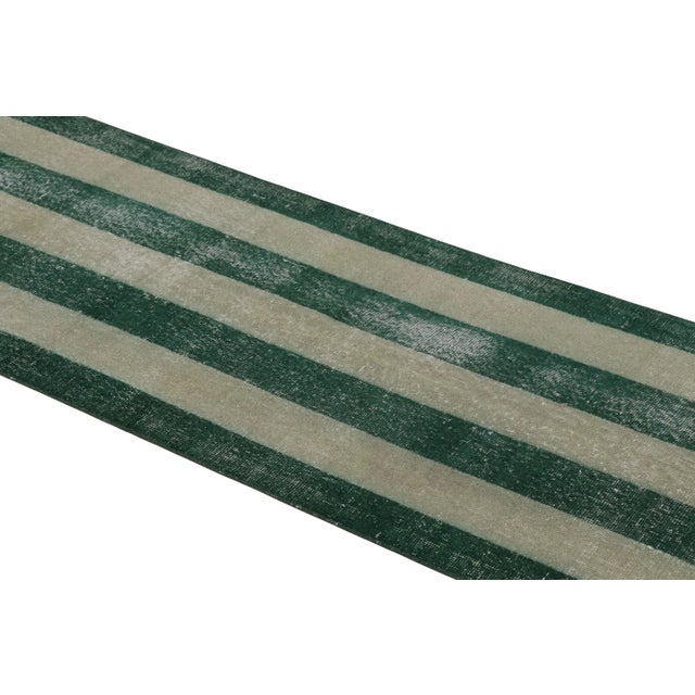 This vintage runner rug is a 3x12 Turkish distressed piece, made with hand-knotted wool circa mid-20th century. It is an...