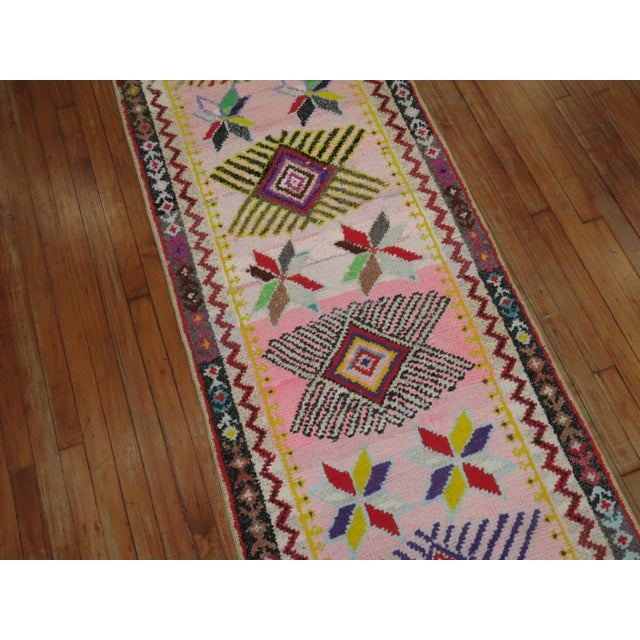 Charming late20th century hand-knotted Turkish Runner featuring a bubble gum pink field with glittered cotton accents...