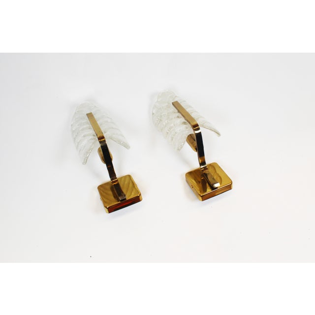Beautiful and high-quality set of wall lamps in solid brass and glass by Fagerlund for Orrefors, Sweden. In very good...