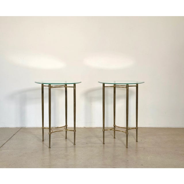 Pair of 1960s coffee tables, worked brass structure, round top in ground and bevelled glass