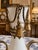 Elegant antique French white opaline vase mounted in an ornate gilt bronze stand with richly detailed tassel...