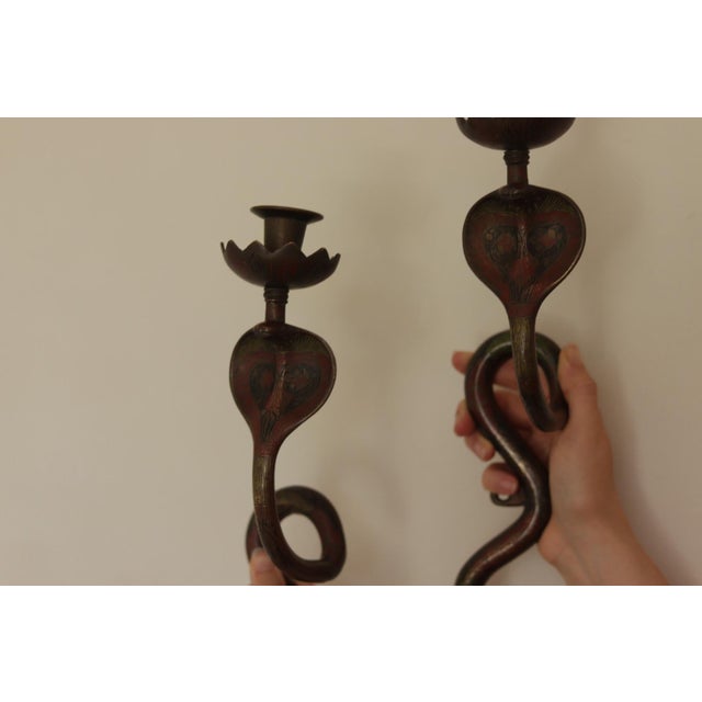 A remarkable pair of enameled brass wall sconces in the Egyptian Revival style featuring a striking single cobra design....