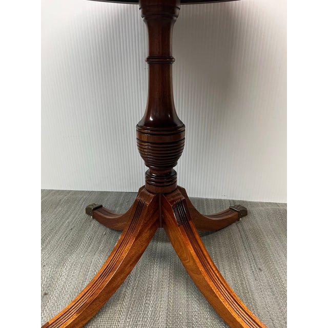 Design Plus Gallery presents a Vintage Duncan Phyfe Style Table. This traditional table has element such as turned base on...