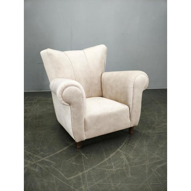 Exceptional Italian lounge armchair produced during the 1950s. Featuring a solid beech wood structure concealed beneath...