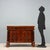 Empire chest of drawers in mahogany crotch. A projecting drawer in the band below the top, three drawers below, turned...