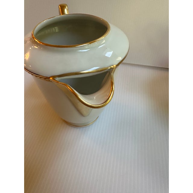 1950s Limoges France set of creamer and sugar bowl with lid, classic white color with gold trim, exuding a timeless elegance.