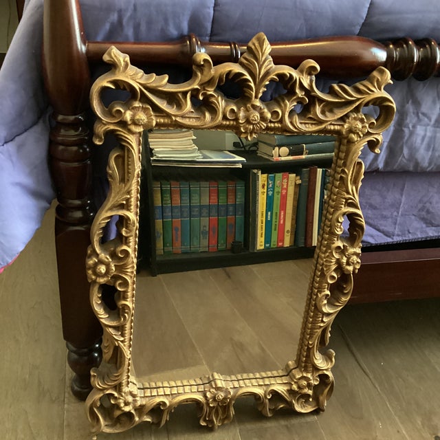 Molded resin gold tone framed wall mirror with elegant floral scrollwork Mirror face size about 19 x 13 inches Full frame...