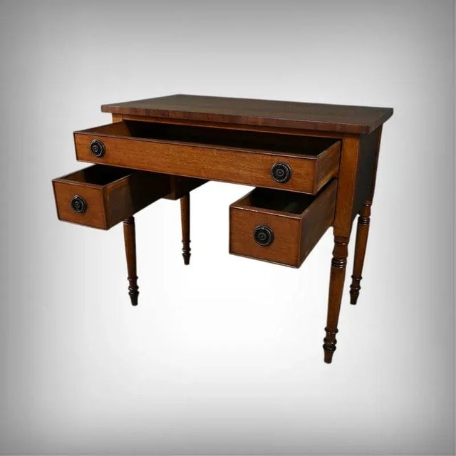 This small solid oak desk, dating from the late Victorian period in England, captivates with its warm patina and fine...