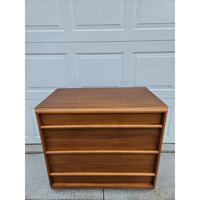 This classic three drawer walnut chest of drawers or dresser is designed by T.H. Robsjohn-Gibbings for Widdicomb out of...