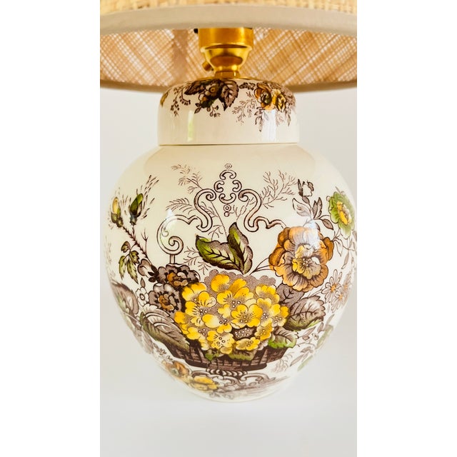 A early 20th century round table lamp made from a vintage ironstone mason’s jar. The lamp features a victorian basket...