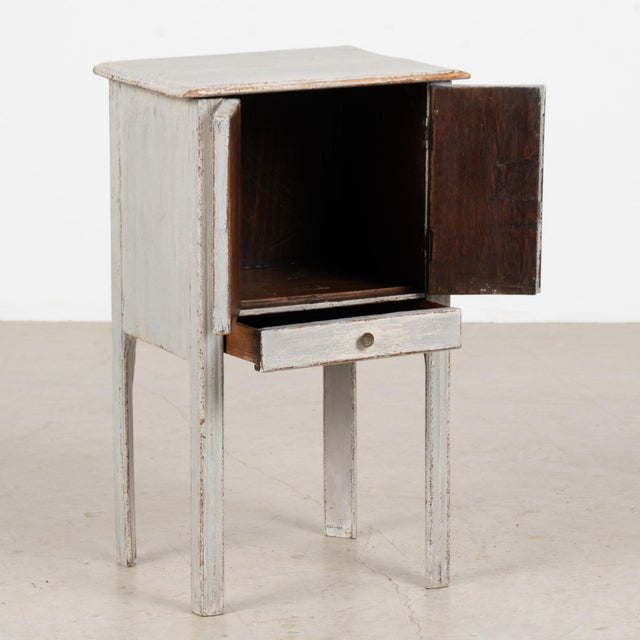 19th century small Swedish cabinet or nightstand, crafted in pine with its original painted finish. Layered blue-gray...