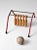 A charming mid-century tabletop bowling game featuring a red-painted metal frame with a back bar and five suspended wooden...