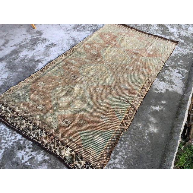 This is a vintage Turkish Anatolian kilim rug from the 1960s. The piece was hand-woven.