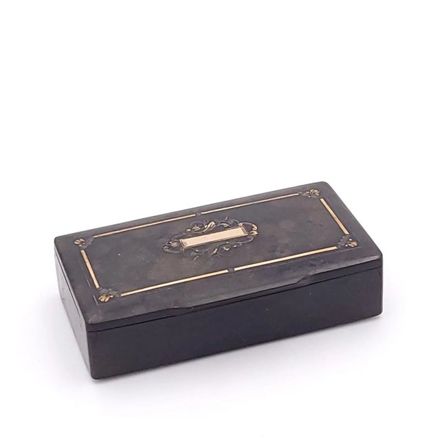 A French papier-mâché snuff box inlaid with gold, circa 1840.