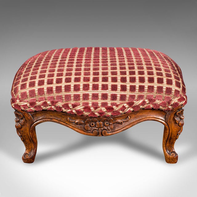 This is an antique footstool. An English, walnut and textile bedroom or lounge stool, dating to the early Victorian...