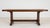 A characterful oak trestle table retaining its original patina, emphasizing authenticity and age. The natural wear...