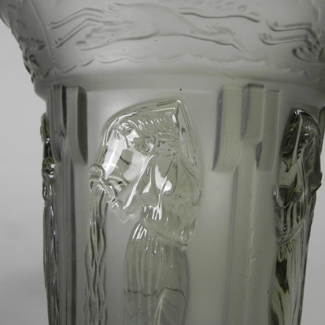 This Art Deco-era model is made of thick-walled, light gray pressed smoked glass. The vase features images of six ladies...