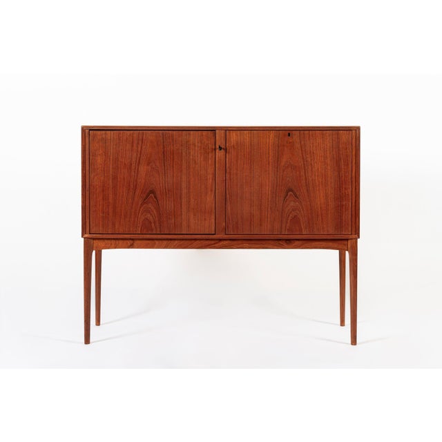 This elegant vintage mid century Scandinavian modern teak bar cabinet with Lazy Susan circa 1960 is attributed to Fredrik...