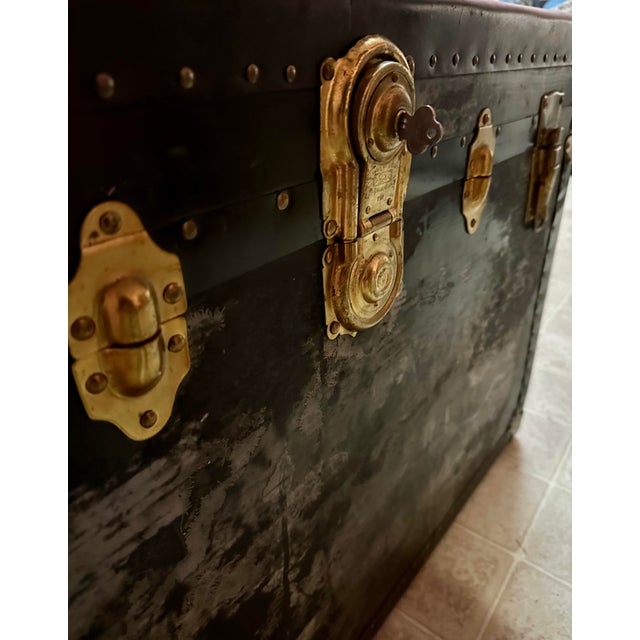 Antique steamer travel trunk. Wrapped in leather with lots of wear, brass hardware, has original key, leather handles on...
