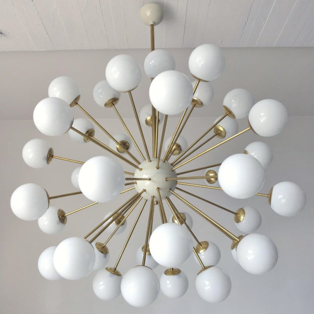 Italian sputnik chandelier with 40 glossy white Murano glass globes mounted on brass frame in lacquered polished brass...