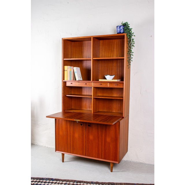 This high-quality teak secretary desk by erik brouer of denmark combines ample storage with a fully functional workspace....