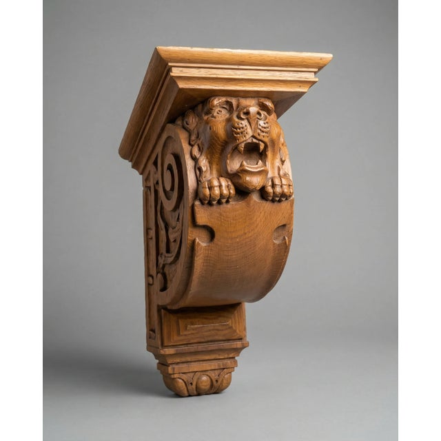 A striking matched pair of antique hand-carved oak corbels featuring bold lion mascarons and deep scrollwork, salvaged...