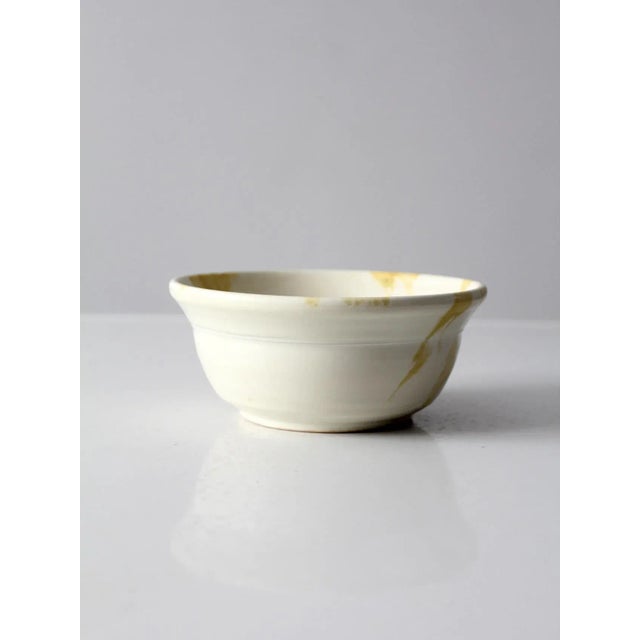 This vintage studio pottery bowl showcases the artistry and individuality of handcrafted ceramics. Signed by the artist,...