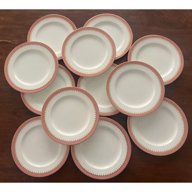 Large set of Coalport dinner plates with a pink edge with gold scalloped trim. The plates were made in England around...
