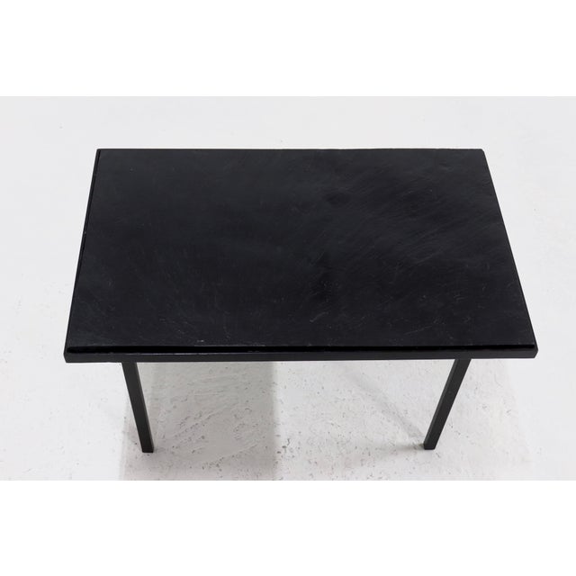 Minimalist side or coffee table sourced in France from the 1960s. The table has black lacquered steel frame with a black...