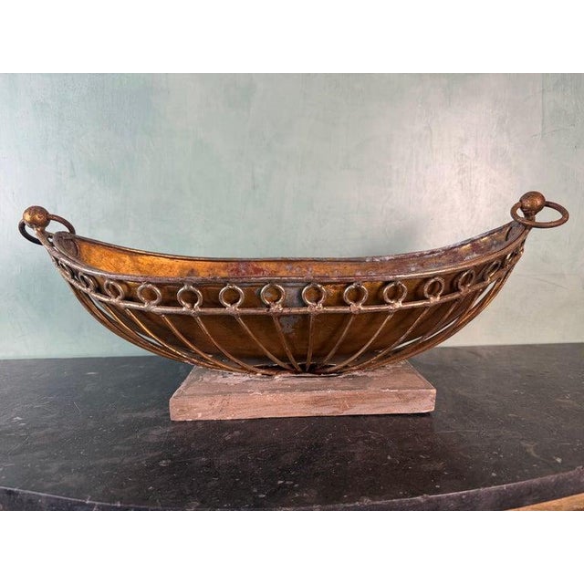 A striking vintage decorative centerpiece bowl featuring a gracefully curved copper vessel supported by an elegant wrought...