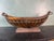 A striking vintage decorative centerpiece bowl featuring a gracefully curved copper vessel supported by an elegant wrought...