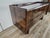 A distinctive 1950s chest of drawers covered in burl wood and featuring four large, roomy drawers. Its sleek design and...