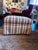 This is a rolling plaid ottoman by Jessica Charles. It is covered in a pinstriped fabric with a fabric skirt covering the...
