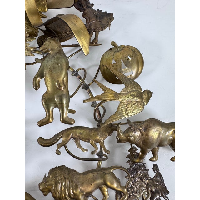 A distinctive all-holiday wreath featuring an assortment of miniature brass animals and seasonal figures, finished with a...