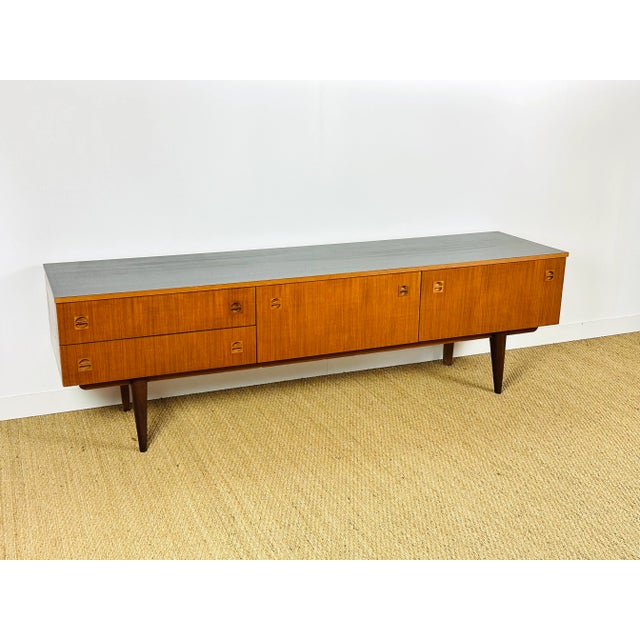 Vintage Scandinavian teak sideboard from the 1960s, featuring two hinged doors and two drawers. Black painted top....