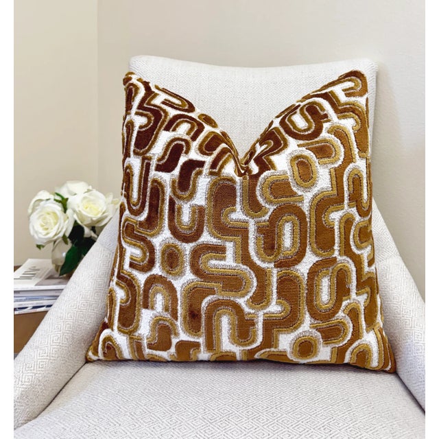 This pillow features a bold bronze velvet pattern set against a textured white bouclé background, blending warmth with...