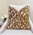 This pillow features a bold bronze velvet pattern set against a textured white bouclé background, blending warmth with...