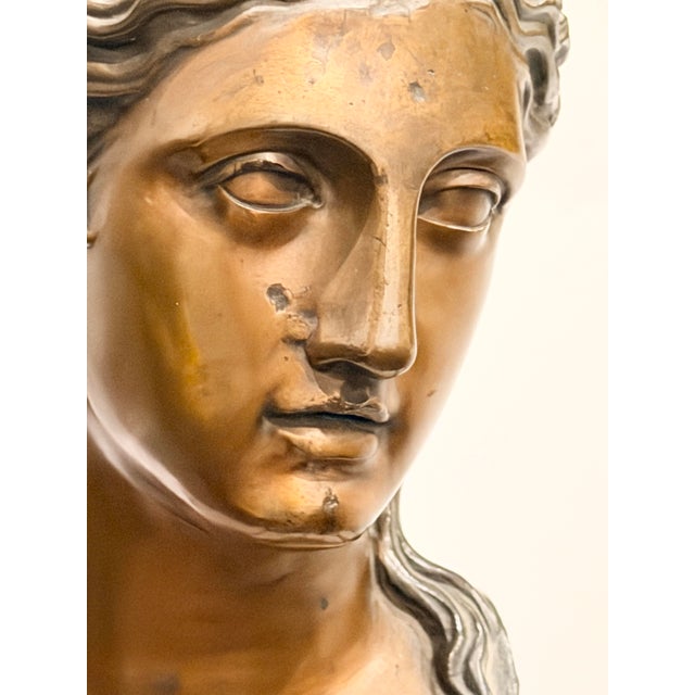 Elevate your décor with this refined bronze bust of a Classical Greek maiden, a model historically associated with Hebe,...