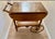 Midcentury 1960s-1970s wood bar cart or tea cart. Solid wood with curvy handle, two small wheels, two side folding panels...